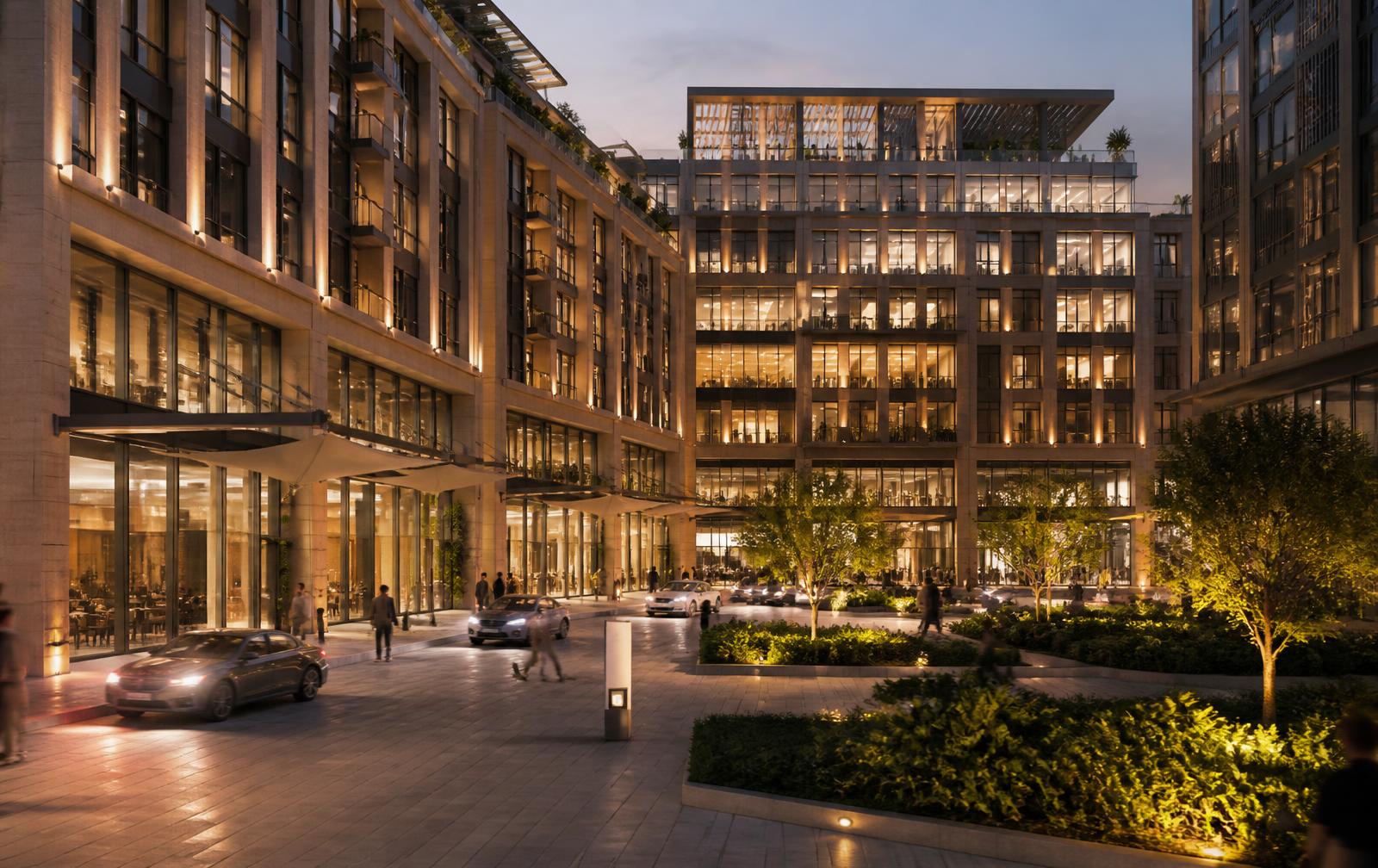 Contemporary mixed-use development with offices, homes, retail and landscaped public realm at dusk