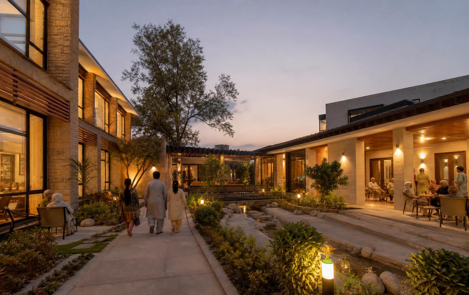 Contemporary healthcare and senior living campus arranged around landscaped gardens at dusk